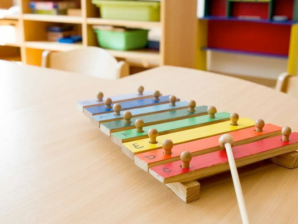 Ein buntes Xylophon liegt auf einem Holztisch in einem Spielzimmer des Mutter-Kind-Hauses.