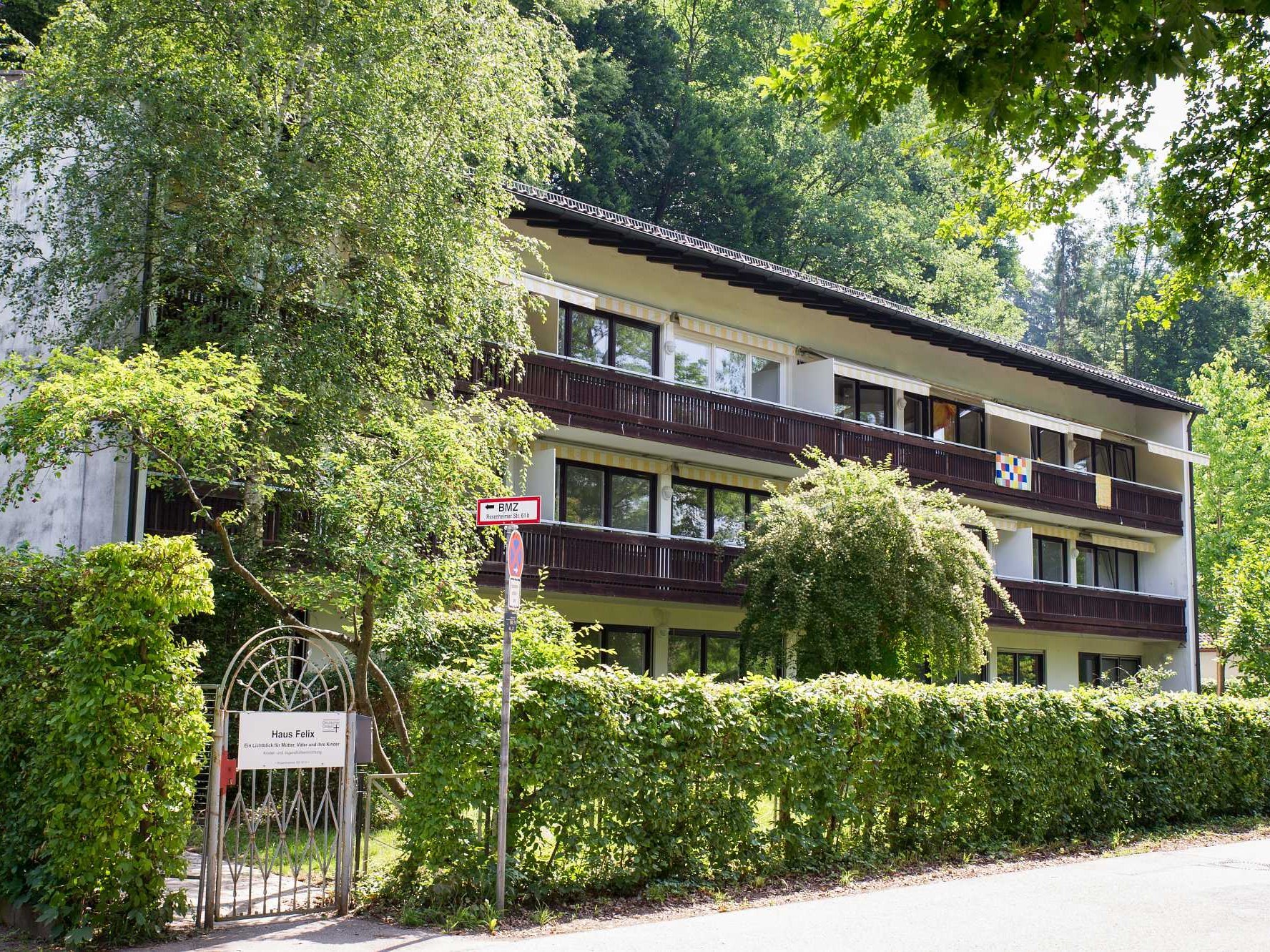 Das Mutter-Kind-Haus Felix fotografiert von außen inmitten von grünen Bäumen